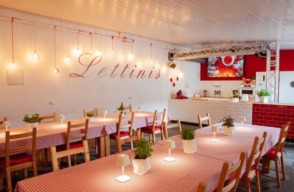Abend im Küchenloft von Lettinis in der Jahnstraße — Gäste an langen Tischen bei italienischem Essen